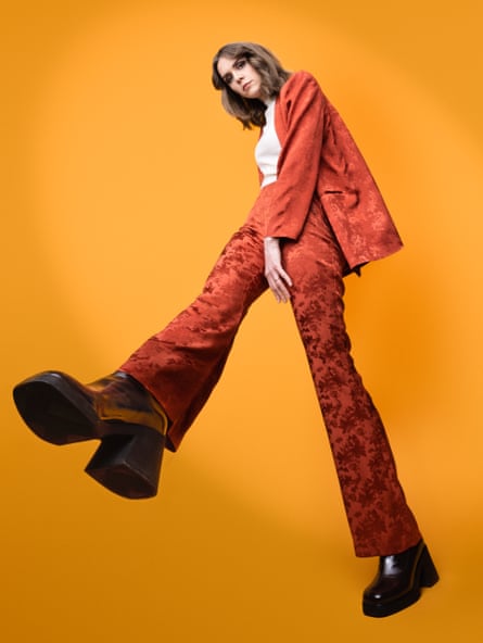 Laura Ramoso dressed in an embossed orange trouser suit