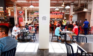 People sit at tables at Grand Central Market in downtown Los Angeles, California, on 24 June amid a record rise in coronavirus cases across the state