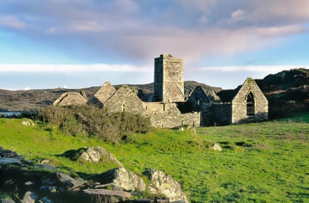 Ruins of old religious building and green fields in Ireland