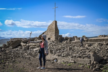 woman takes photo in front of ruined church
