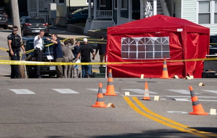 police stand outside on street blocked off with yellow tape