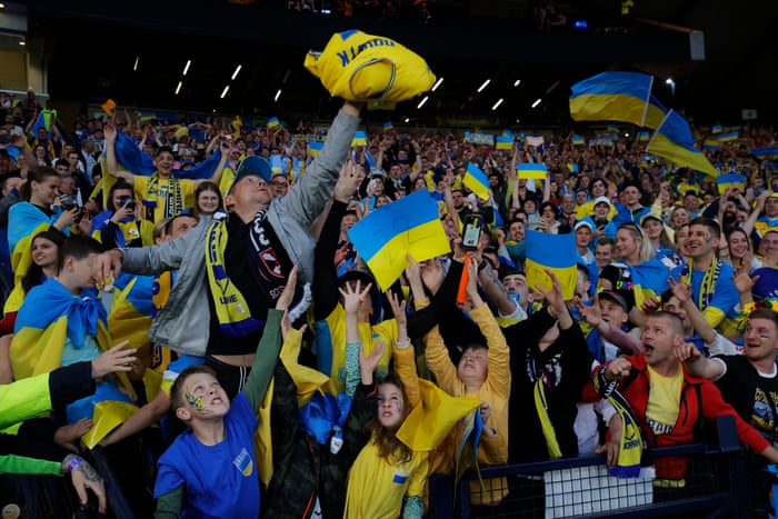 Ukraine fans reach for Artem Dovbyk’s shirt after he threw it into the crowd as they celebrate their team’s victory.