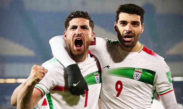 Iran players Mehdi Taremi and Alireza Jahanbakhsh celebrate qualification for the Qatar World Cup.
