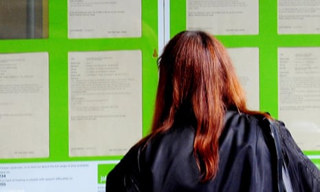 A woman looks into the window of a job centre
