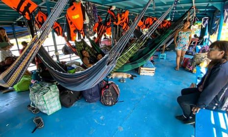 Foreign and Peruvian travellers wait in the boat where they were detained at the Cuninico community in Loreto, north of Peru, on Friday.