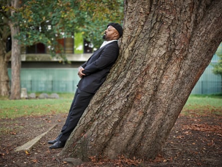 Ben Okri leaning against a tree