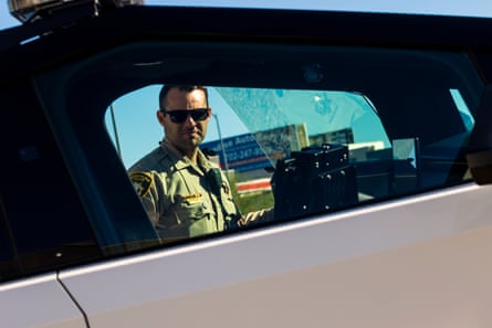 a man in sunglasses looking into the window of a vehicle