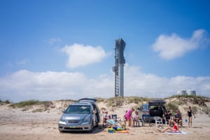 People spend time on the beach near the Starship Flight 3 rocket a day before its scheduled launch at the Starbase facility near Boca Chica beach in Brownsville, Texas, US