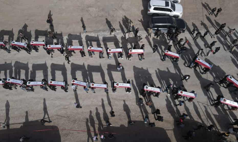 An aerial view of mourners carrying coffins during a funeral for Yazidis found in a mass grave in the village of Kojo, northern Iraq, in December 2021