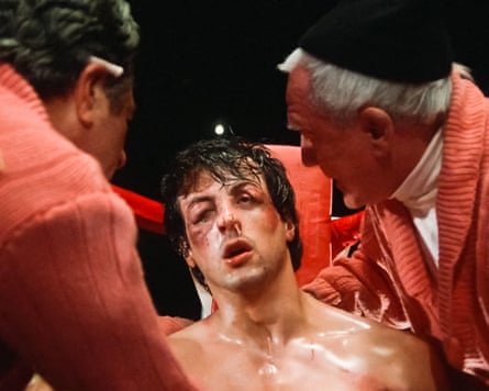 Rocky, bruised and exhausted, is tended to by his cornermen between rounds