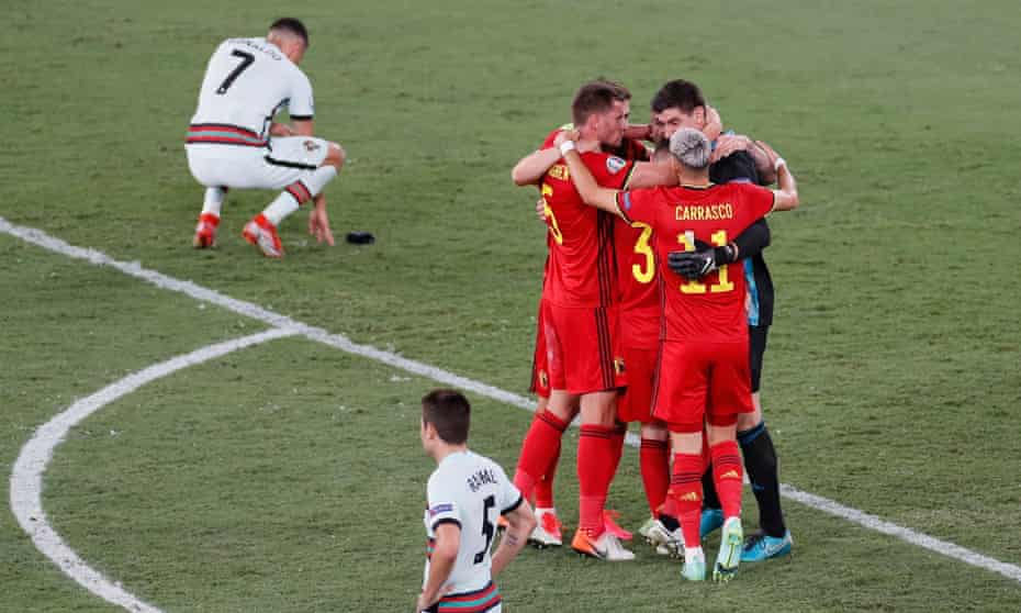 Cristiano Ronaldo (top) contemplates defeat as Belgium’s players celebrate after the final whistle.