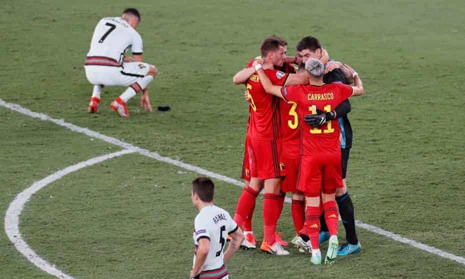 Cristiano Ronaldo (en haut) envisage la défaite alors que les joueurs belges célèbrent après le coup de sifflet final.