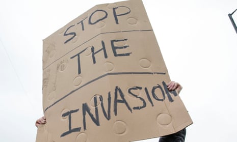 A sign reading 'stop the invasion' at an anti-immigration protest