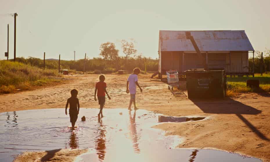 Aboriginal kids walking trough a puddle in
Broome, Western Australia.