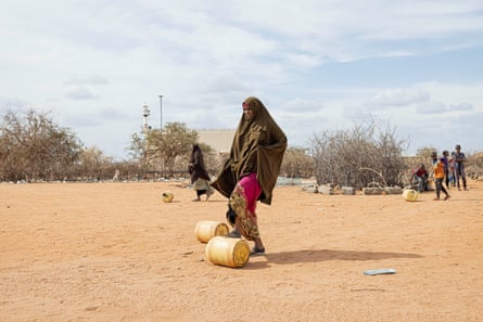 زنی یک قوطی پر از آب را در Afwein در Garissa هل می دهد