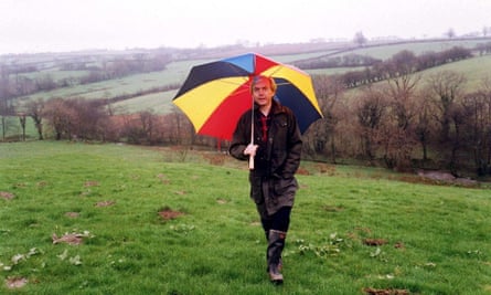 Humphrys walks in a field with an umbrella to protect him from the rain. He is said to love walking, particularly in Wales.