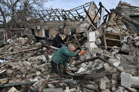 Two men sorting the wreckage of a bombed house