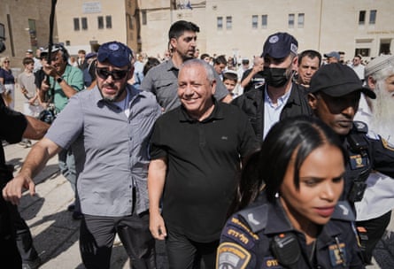 Gadi Eisenkot smiles while walking through a crowd at the Western Wall, escorted by police