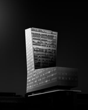 A boot-shaped office building illuminated at night