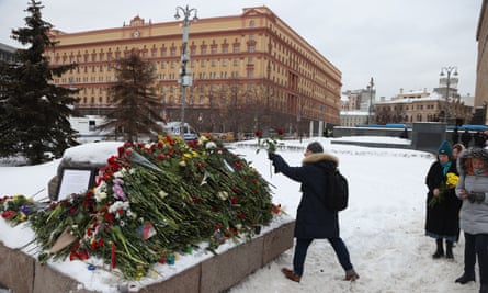 People lay flowers in tribute to Navalny at the Solovetsky stone in Lubyanka Square, Moscow, 17 February 2024.