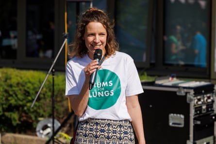 Woman speaks into microphone at campaign rally.