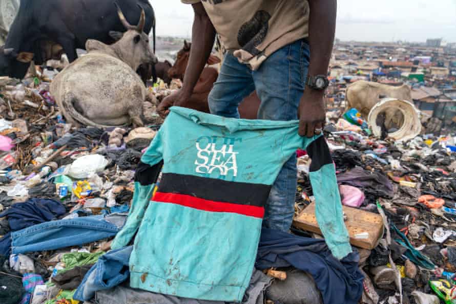 A waste worker in Accra sorts through discarded secondhand clothes sent from the west.