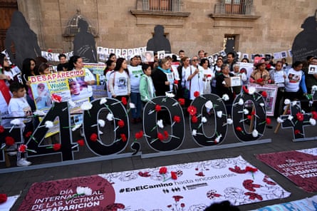People hold pictures of missing persons in front of the National Palace during the commemoration of the International Day of the Disappeared in Mexico City, on August 30, 2019.