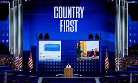 A woman speaks on stage with the words "Country first" behind her
