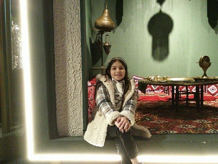 Layla sits in a home by some rugs