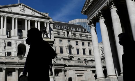 People wearing masks walk past the Bank of England