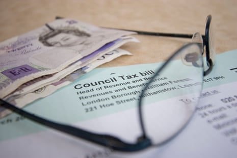 Banknotes and eyeglasses rest on top of a UK council tax bill letter