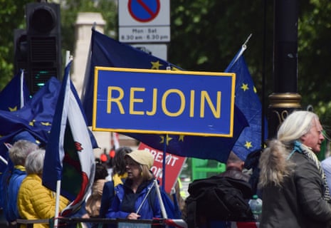 Anti-Brexit activists hold a banner that says ‘Rejoin’ in Parliament Square