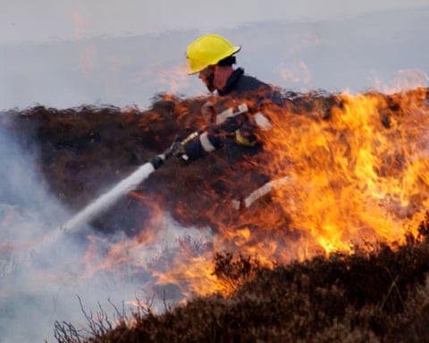 Firefighter hoses down wildfire on heather moorland
