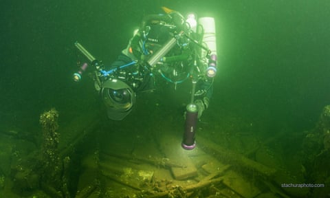 One of the Polish divers exploring the sunken vessel, which was found to be carrying mineral water and porcelain as well as champagne eiqeuideeiqquinv