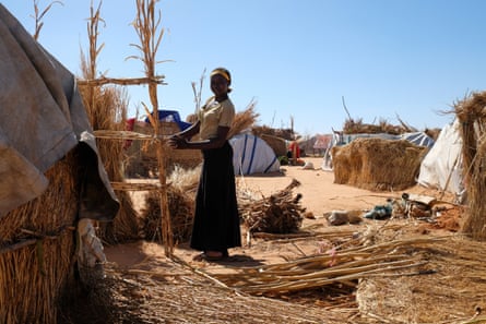 Sudanlı bir mülteci, Çad'ın doğusundaki sınır kasabası Adré'de çimden bir kulübe inşa ediyor.
