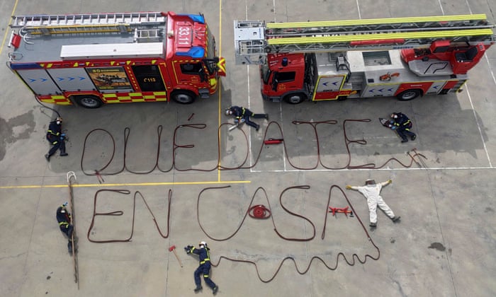 Firefighters perform an action and write the message ‘Stay at Home’, with their fire hoses in the town outside Madrid, Spain