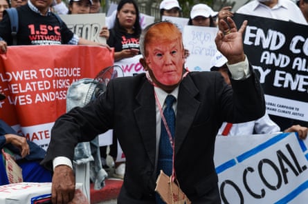 An environmental activist wearing a face mask depicting US President Donald Trump takes part in a demonstration in front of the United Nations building in Bangkok.