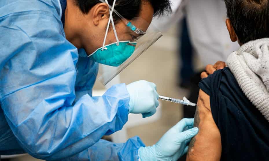 A patient receives a Covid vaccine at the Los Angeles Mission in Skid Row on 10 February. 