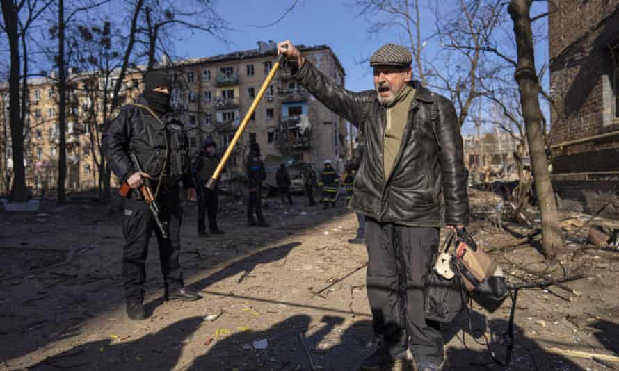 A man shouts anti-Russian slogans near bomb-damaged residential buildings in Kyiv on Friday.