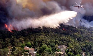 A heavy lift helicopter drops water on a bushfire threatening homes in the northern suburbs of Sydney.