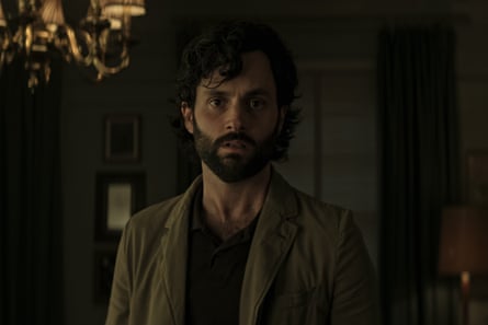 Penn Badgley with beard and longish in a dark room as Joe Goldberg in You.
