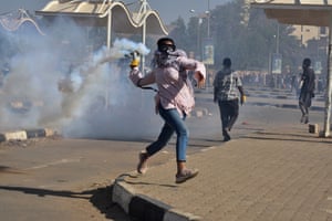 A protester throws back a tear-gas canister that had been fired by security forces, during a march demanding an end to military rule, in Khartoum, Sudan, on 30 December 2021