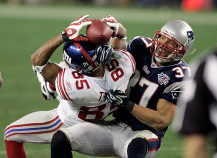 New York Giants receiver David Tyree (85) holds on by his fingertips to a 32-yard pass as New England Patriots safety Rodney Harrison (37) pulls him down after the catch during the fourth quarter of the Super Bowl football game Sunday, Feb. 3, 2008 in Glendale, Ariz