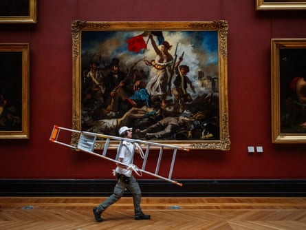 A Louvre worker carrying a step ladder passes in front of Liberty Leading the People, 1830, by Eugene Delacroix.