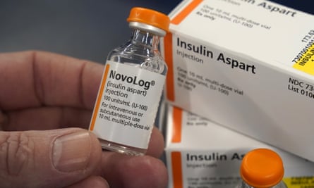 A hand holding a bottle of insulin
