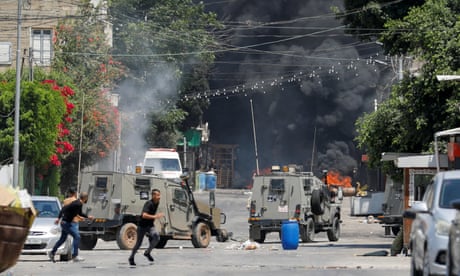 Palestinians run for cover during clashes with Israeli forces in Jenin on Monday