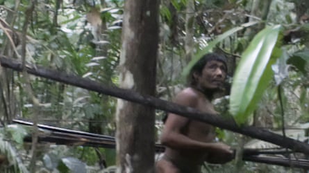 Fuzzy photo of a member of the Kawahiva people running through the forest.