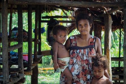 A mother and her children, residents of a village that is slowly being submerged by rising tides.