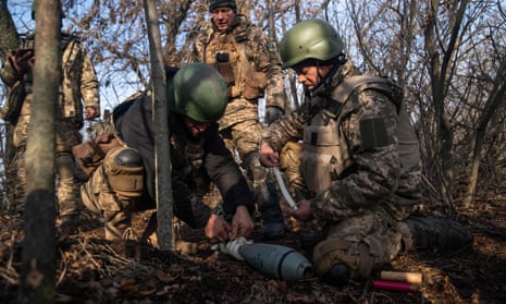 Ukrainian soldiers from the 68th brigade prepare a 120mm round to fire from a mortar launcher at a position along the frontline in Donetsk region.