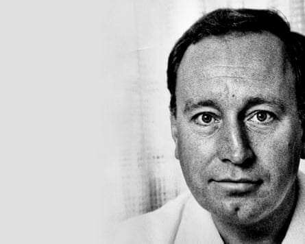 A black-and-white portrait of Michael Briggs, smiling very weakly and looking at the camera